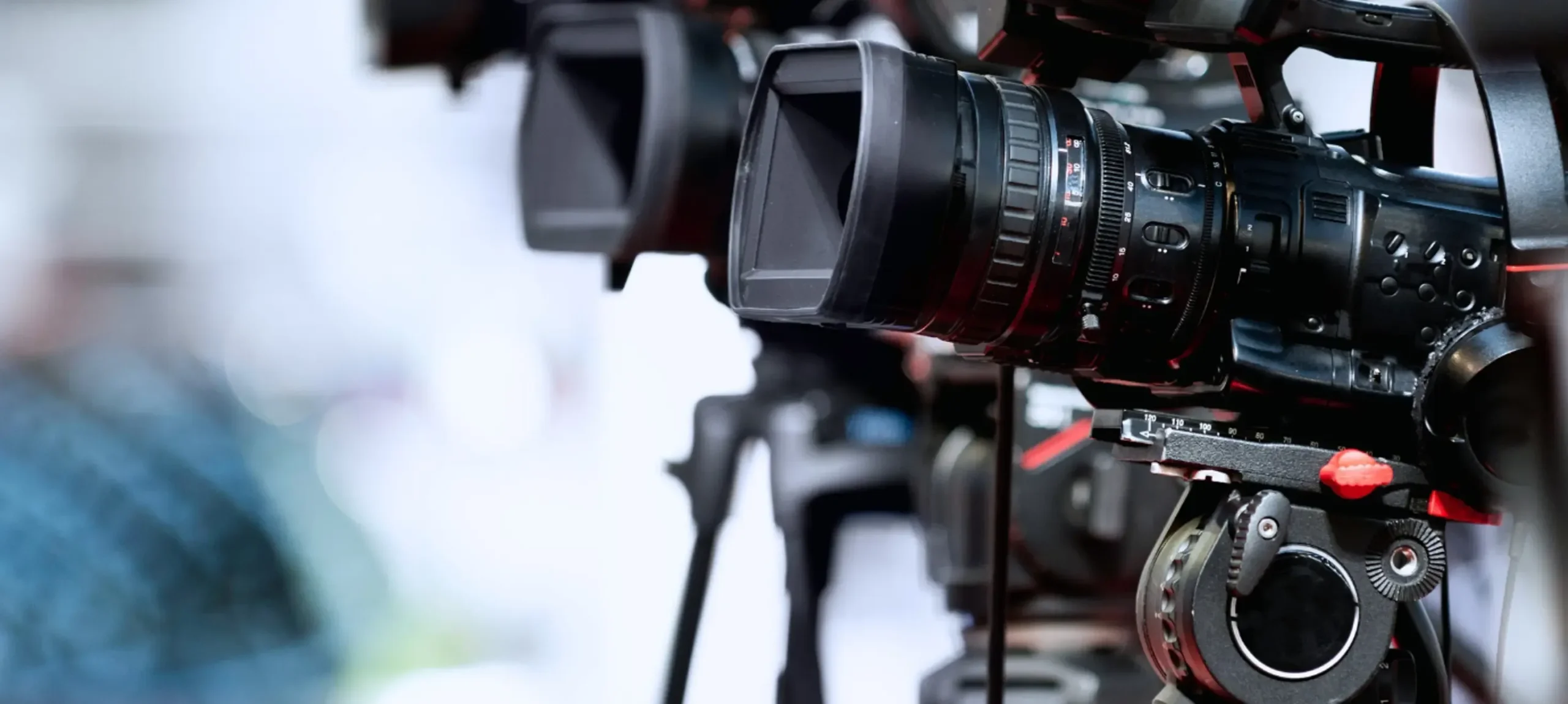 Close-up of professional video cameras on tripods, showcasing lenses and equipment used in video production, relevant to Marketania's portfolio of impactful video services.