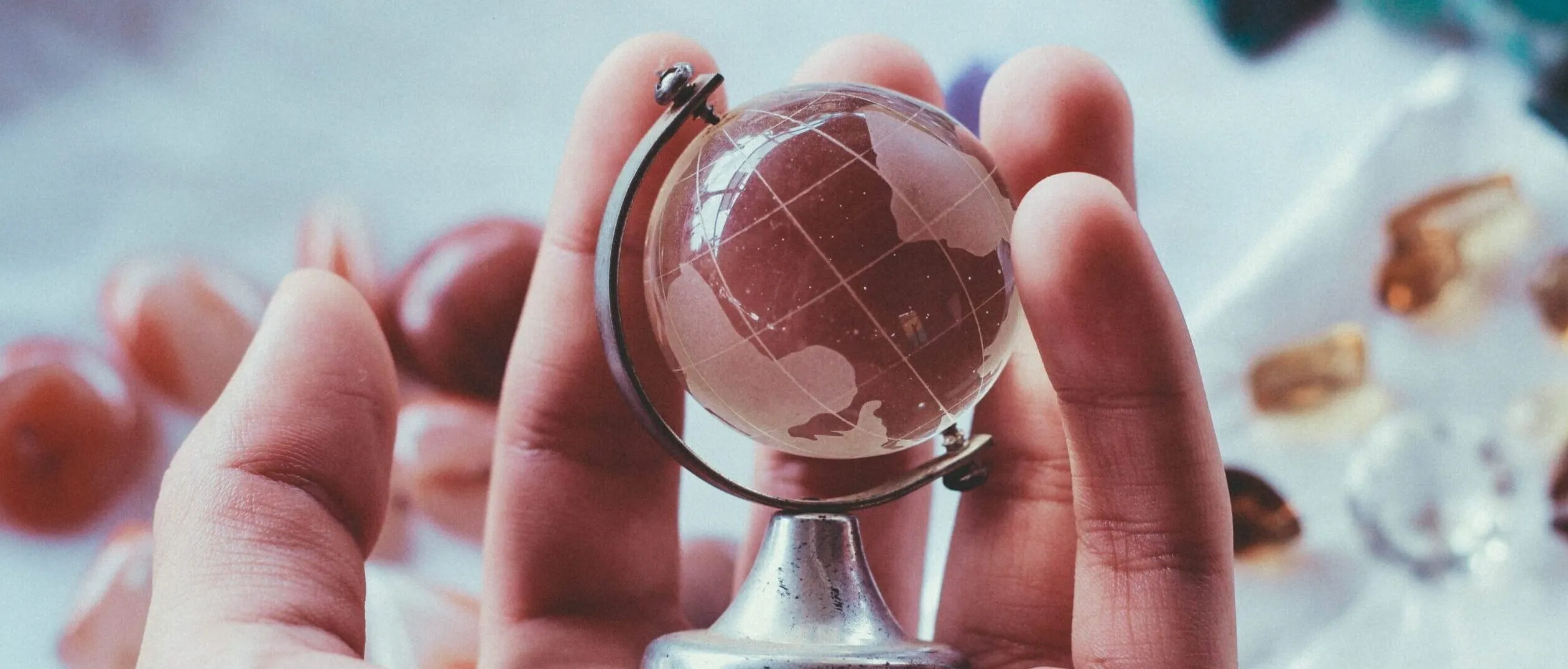 Hand holding a small globe, symbolizing global SEO services and international marketing strategies for business growth.