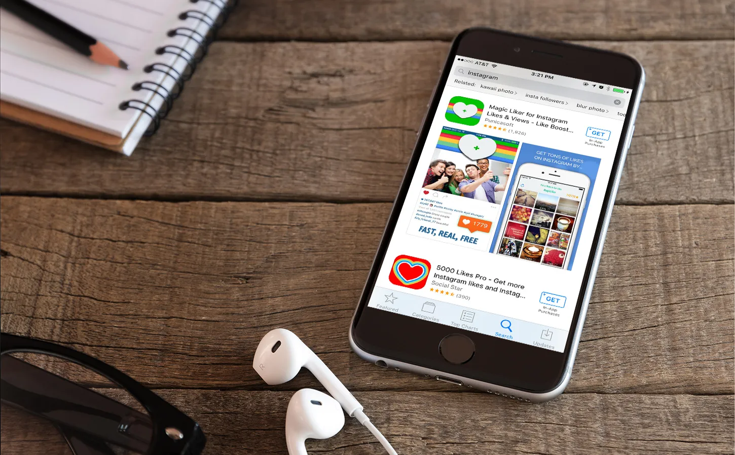 Smartphone displaying app store interface featuring Instagram and promotional apps for increasing likes, with notebook and earphones on wooden surface.