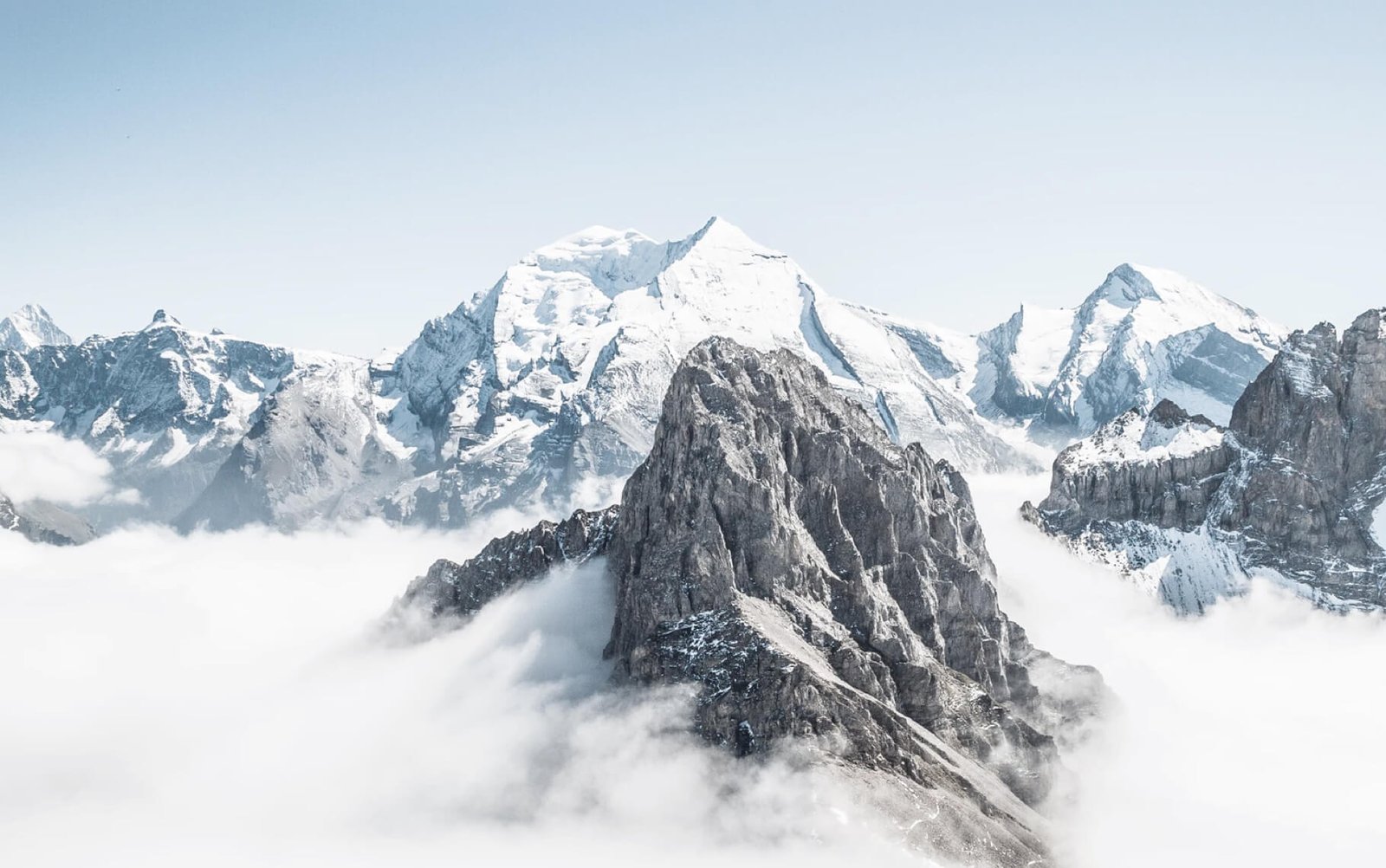 Snow-capped mountains rising above clouds, representing limitless possibilities for creative web design and digital solutions.